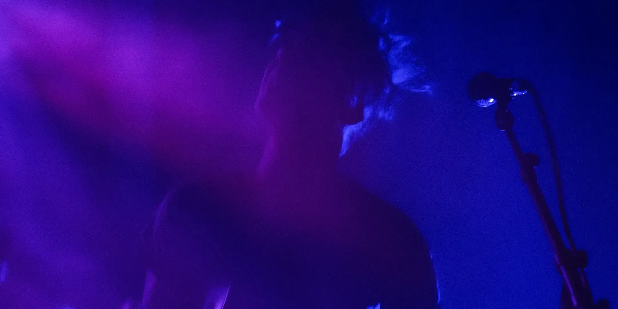 The band on stage in blue light