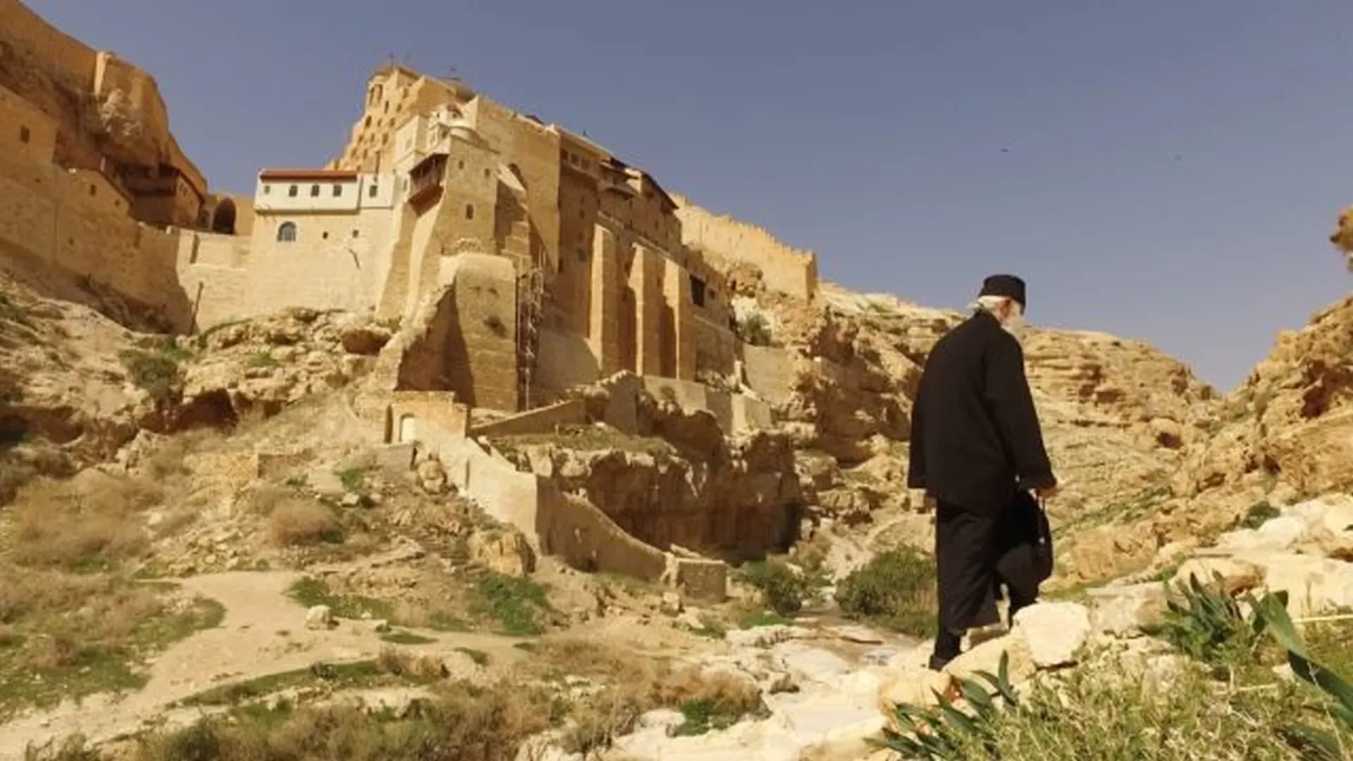 A monk walking below the Great Lavra of Saint Sabbas