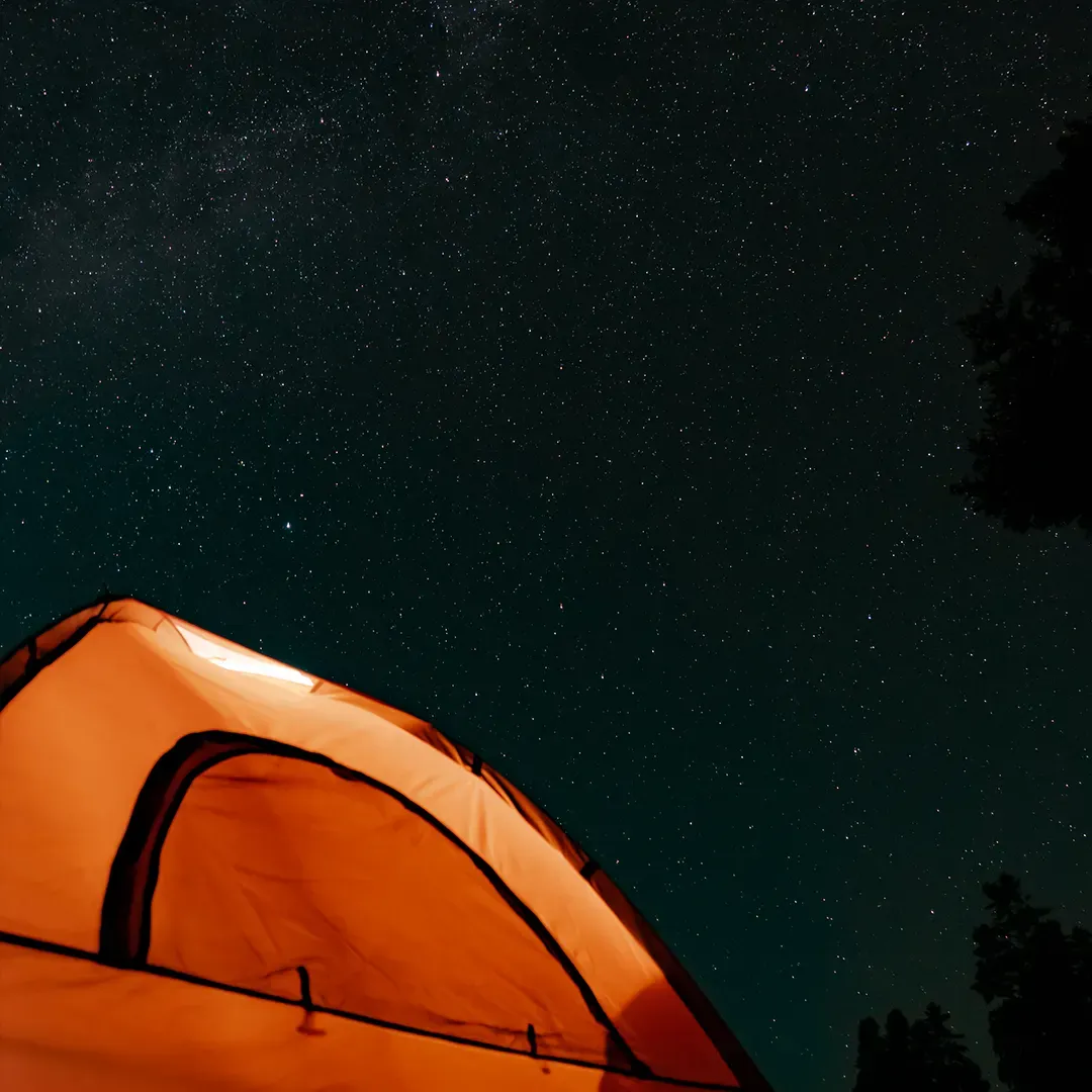 A lit tent under the stars