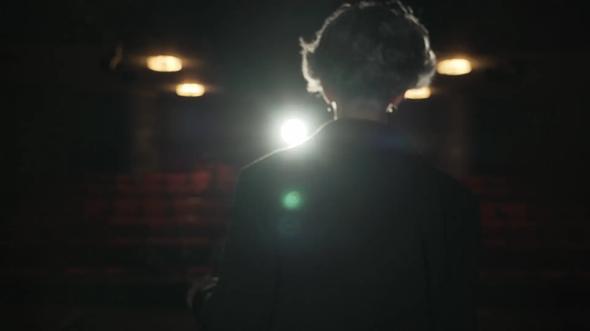 A figure under a single light in a theatre